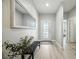Bright entryway featuring a decorative front door, light wood floors, bench, and a large mirror at 3025 Winglewood Cir, Lutz, FL 33558