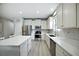 Modern kitchen featuring stainless steel appliances, a kitchen island, and bright white cabinets at 3025 Winglewood Cir, Lutz, FL 33558