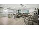 Open-concept living room features a large sectional sofa, with white walls, and light floors at 3025 Winglewood Cir, Lutz, FL 33558