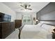 Comfortable main bedroom with a king bed, natural light, and dark wood furniture at 3025 Winglewood Cir, Lutz, FL 33558
