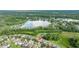 Aerial view of single Gathering homes, lawns, and a lake in the background, location marked with red pin at 3025 Winglewood Cir, Lutz, FL 33558