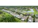 Aerial view of neighborhood featuring single Gathering homes, lawns, pond, and surrounding trees at 3025 Winglewood Cir, Lutz, FL 33558