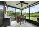View of the enclosed patio's bar area, which has a fridge, a bar and backyard views at 3025 Winglewood Cir, Lutz, FL 33558