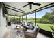 Wide view of the enclosed patio with seating, bar area, ceiling fans and green backyard at 3025 Winglewood Cir, Lutz, FL 33558