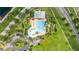 Aerial view of the community pool with a slide, splash area, sun loungers, landscaping, and parking at 3025 Winglewood Cir, Lutz, FL 33558