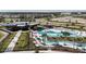 Aerial view showcasing the community pool with a lazy river, sun loungers, and well-manicured landscaping at 31504 Hayman Loop, Wesley Chapel, FL 33545