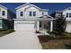 Charming two-story home featuring light gray siding, a two-car garage, and a welcoming front entrance at 3275 Guanabana Xing, Wesley Chapel, FL 33543