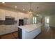 Open kitchen design with modern white cabinets, an island, stainless appliances, and stylish pendant lighting at 3275 Guanabana Xing, Wesley Chapel, FL 33543