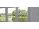 Picturesque view of a serene lake and lush greenery visible through the multiple windows at 3275 Guanabana Xing, Wesley Chapel, FL 33543