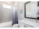A modern bathroom featuring a shower and bathtub combination, tile walls, and an elegant mirror above the sink at 3603 Tour Trce, Land O Lakes, FL 34638