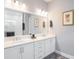 Bright bathroom with double vanity, white cabinetry, and a large mirror with stylish lighting at 3603 Tour Trce, Land O Lakes, FL 34638