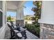 Charming front porch with stone accents, pillars, and comfortable Adirondack chairs at 3603 Tour Trce, Land O Lakes, FL 34638
