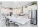 Bright kitchen features an island with seating, white cabinetry, modern stainless steel appliances, and stone countertops at 3603 Tour Trce, Land O Lakes, FL 34638