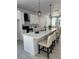 Well-lit kitchen featuring white cabinets, a spacious island with barstool seating, and modern light fixtures at 4200 N 15Th St, Tampa, FL 33610