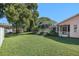 Grassy backyard featuring lush greenery and a screened-in patio at 4355 Odin St, Spring Hill, FL 34608