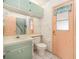 Bathroom with vanity, toilet, and window, alongside a door and shower at 4355 Odin St, Spring Hill, FL 34608