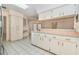 Spacious kitchen featuring white cabinets, tile flooring, and a breakfast bar at 4355 Odin St, Spring Hill, FL 34608