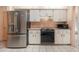 A kitchen area with white cabinets and a stainless steel refrigerator and black oven at 4355 Odin St, Spring Hill, FL 34608