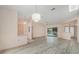 Spacious living area with light flooring, decorative chandeliers, and access to outdoor patio at 4355 Odin St, Spring Hill, FL 34608