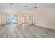 Spacious living room with light grey flooring, modern chandeliers, and natural light at 4355 Odin St, Spring Hill, FL 34608
