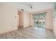 Bright living room featuring wood-look floors and sliding glass doors leading to a screened lanai at 4355 Odin St, Spring Hill, FL 34608