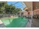 Enclosed pool area with a screened enclosure, patio, and steps into the pool at 4355 Odin St, Spring Hill, FL 34608