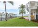 Beautiful waterfront backyard with lush green grass, palm trees, and private dock at 442 Midway Is, Clearwater Beach, FL 33767