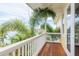 Exterior view of a wooden balcony with white railing overlooking a waterway and palm trees at 442 Midway Is, Clearwater Beach, FL 33767