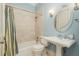 Bathroom featuring a single sink vanity, shower with tub, and blue walls at 442 Midway Is, Clearwater Beach, FL 33767