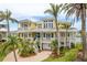 Stunning yellow waterfront home featuring multi-level balconies and lush tropical landscaping at 442 Midway Is, Clearwater Beach, FL 33767