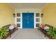 Lovely covered porch with seating and bright blue double doors and lantern lighting at 442 Midway Is, Clearwater Beach, FL 33767