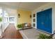 Charming front porch with bright blue double doors and a cozy bench with pillows at 442 Midway Is, Clearwater Beach, FL 33767