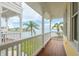 This yellow home features an outdoor patio with wood floors and views of the water and nearby palm trees at 442 Midway Is, Clearwater Beach, FL 33767