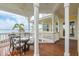 Covered outdoor patio features wood floors, comfortable seating, and stunning water views with palm trees at 442 Midway Is, Clearwater Beach, FL 33767