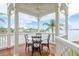 Waterfront outdoor patio features a ceiling fan, wood floors, and comfortable seating at 442 Midway Is, Clearwater Beach, FL 33767