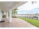 Covered patio with waterfront views, lush landscaping, and outdoor living space at 442 Midway Is, Clearwater Beach, FL 33767