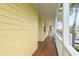 Bright porch with wood floors and white railings; view shows lush landscaping and waterfront at 442 Midway Is, Clearwater Beach, FL 33767