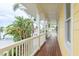Extended porch with wood floors, white railings, and waterfront views surrounded by lush greenery at 442 Midway Is, Clearwater Beach, FL 33767