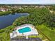 Aerial view showcasing the swimming pool amenity overlooking a serene lake and lush surroundings at 4540 Overlook Ne Dr # 246, St Petersburg, FL 33703