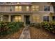 Charming townhouse featuring a stucco facade, lush landscaping, and inviting entryway at dusk at 4668 66Th N Pl, Pinellas Park, FL 33781