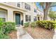 Well-maintained townhouse featuring a green door, lush landscaping, and inviting walkway at 4668 66Th N Pl, Pinellas Park, FL 33781