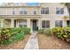 Charming townhouse featuring a stucco facade, lush landscaping, and inviting entryway at 4668 66Th N Pl, Pinellas Park, FL 33781