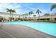Community pool with lounge chairs surrounded by lush landscaping and well-maintained buildings with black fencing for privacy at 4668 66Th N Pl, Pinellas Park, FL 33781