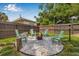 A charming backyard fire pit area, surrounded by white rock and Adirondack chairs, perfect for outdoor relaxation at 5101 N Suwanee Ave, Tampa, FL 33603