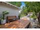 Landscaped backyard with a wooden deck, lounge area, and tropical plants at 5101 N Suwanee Ave, Tampa, FL 33603