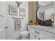 Modern bathroom with a stylish vanity, round mirror, and decorative accents at 5101 N Suwanee Ave, Tampa, FL 33603