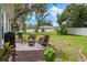 Backyard patio area with outdoor seating, beautiful green lawn, and mature shade trees at 5301 Bayonne Ave, Spring Hill, FL 34608