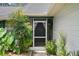 Close-up of a cozy front porch with decorative accents, lush plants, and screened door at 5301 Bayonne Ave, Spring Hill, FL 34608