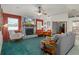 Cozy living room featuring a brick fireplace, seating area, ceiling fan, and views to other rooms at 5301 Bayonne Ave, Spring Hill, FL 34608