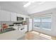 Bright kitchen features white cabinets, a window, tile floors, laminate countertops, and modern appliances at 547 Summer Sails Dr, Valrico, FL 33594